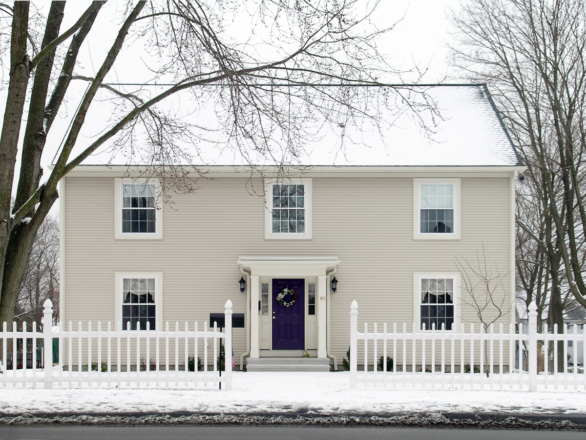 front exterior of American colonial traditional home in snowy winter weather